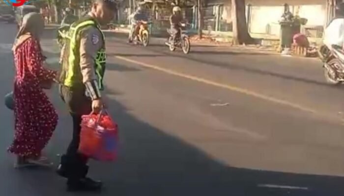 Bantu Ibu Rumah Tangga Menyeberang di Area Pasar, Anggota Satlantas Polres Sampang Menuai Pujian